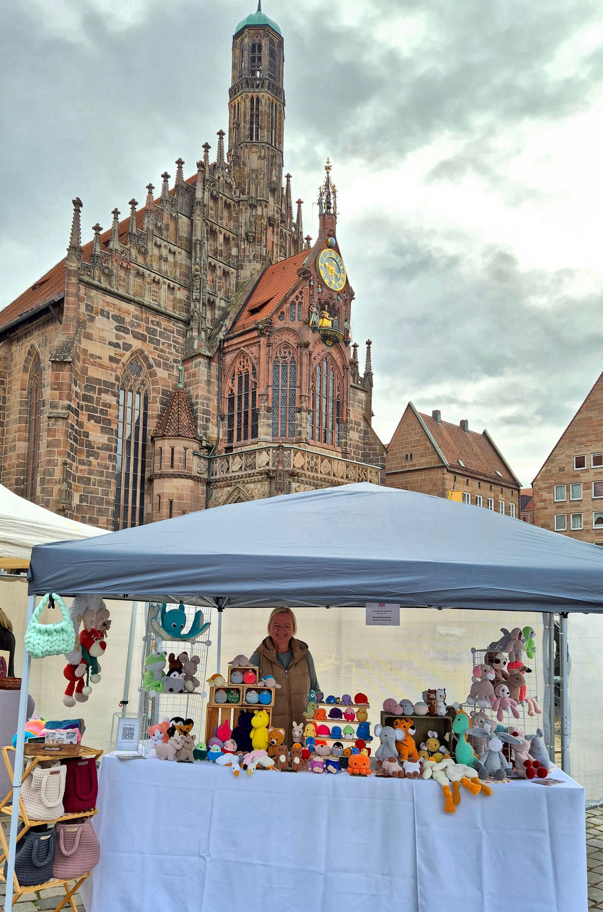 Ein Marktstand mit handgefertigten Artikeln vor einer großen Kirche.