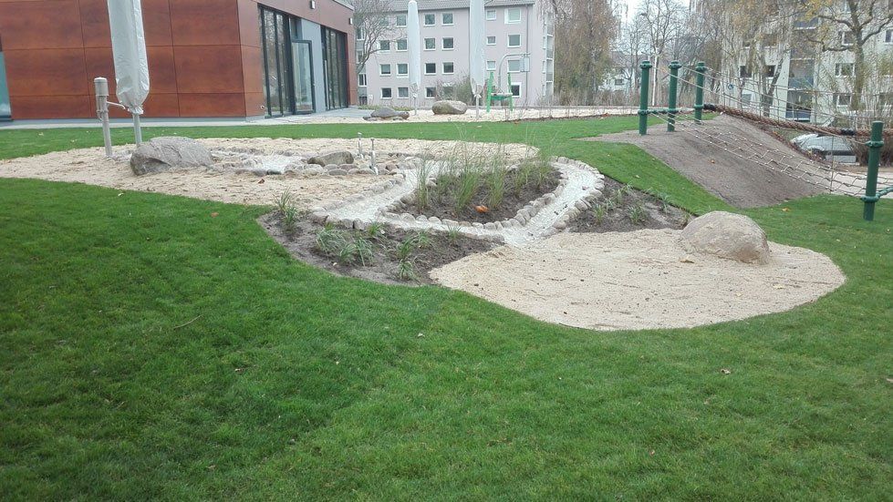 Matschplatz mit Findling und Sandfläche