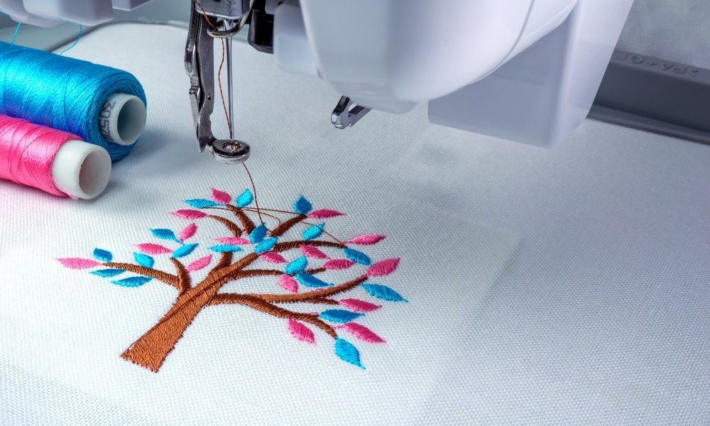 an embroidery machine stitching a colorful tree
