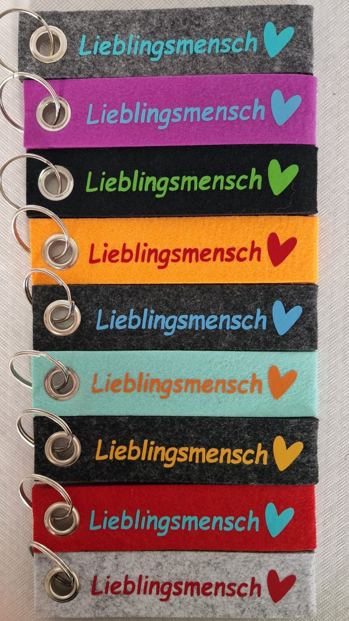 Bunte Schlüsselanhänger mit dem Schriftzug „Lieblingsmensch“ und Herzsymbolen.