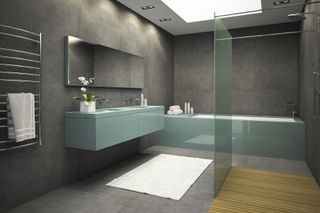 Distribución de bañera y ducha en un espacio unificado por piedra caliza en pared y suelos.