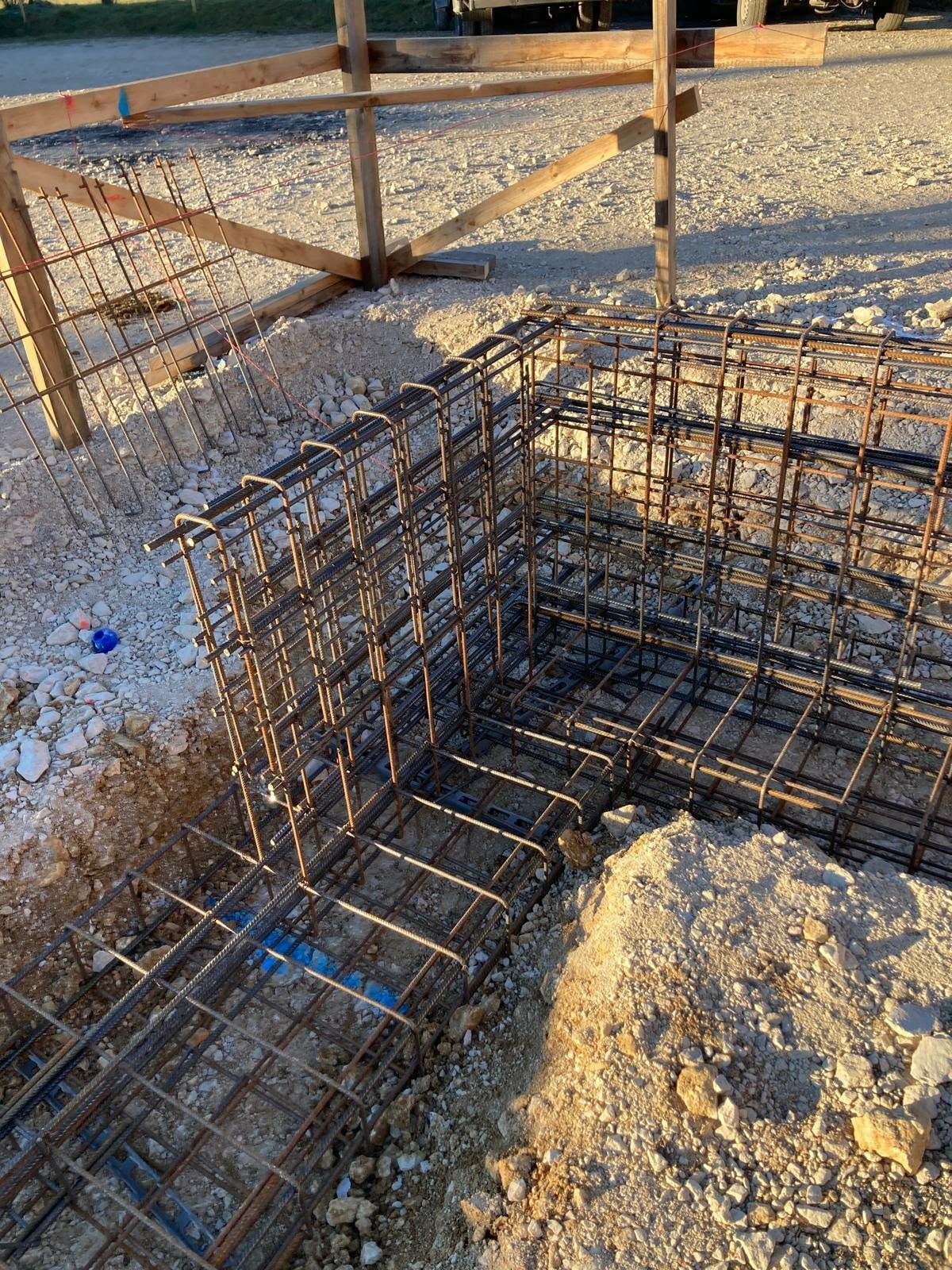 Stahlbewehrungsrahmen für ein Eckfundament auf einem Kiesbett auf einer Baustelle.
