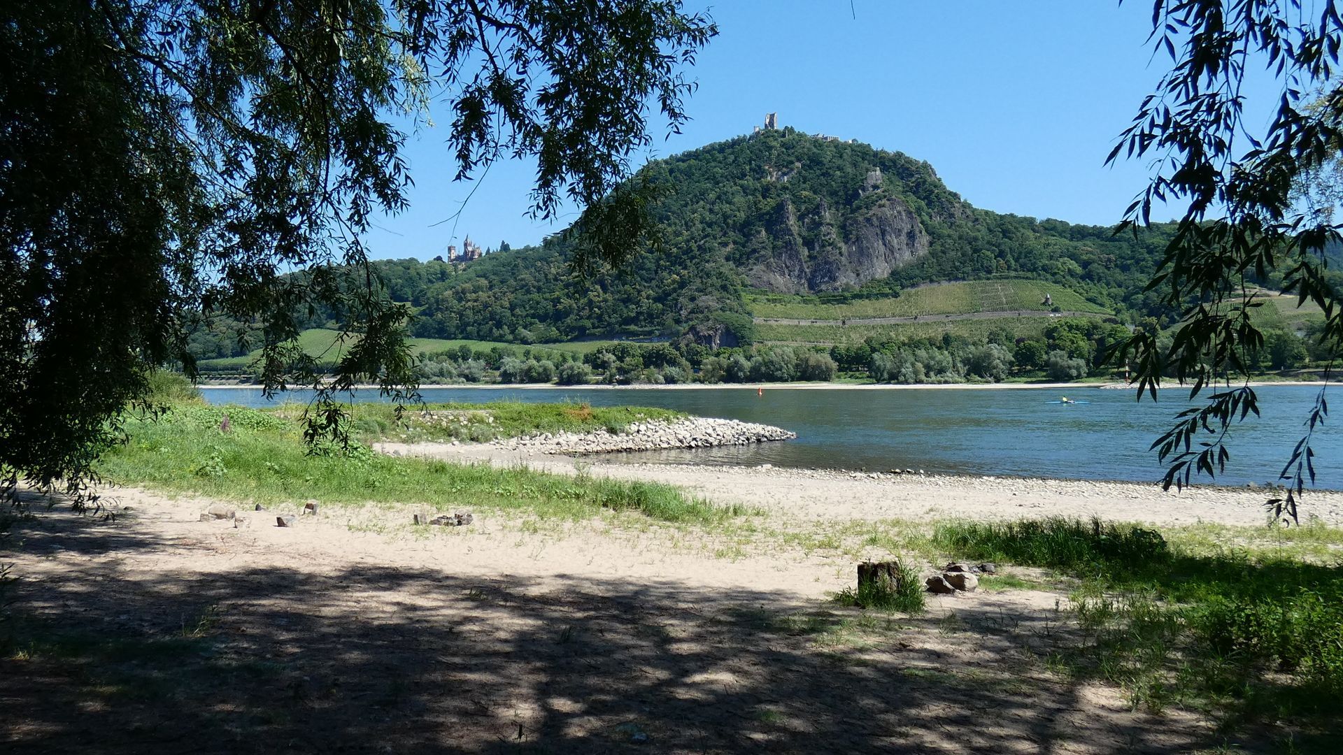 Romantisches Boho Picknick zu zweit am Rhein. Stilvolle Deko mit Kissen, und Blick aufs Wasser.