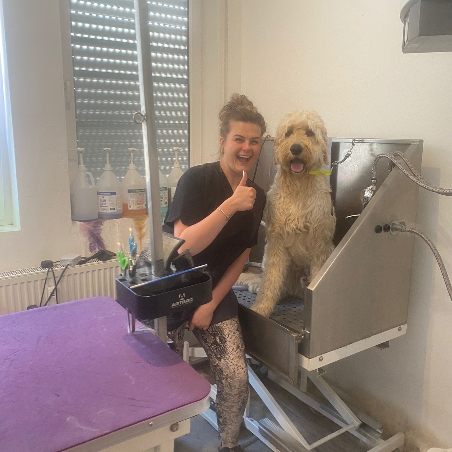 Lana Topmöller mit einem Hund der in der Badewanne gewaschen wird