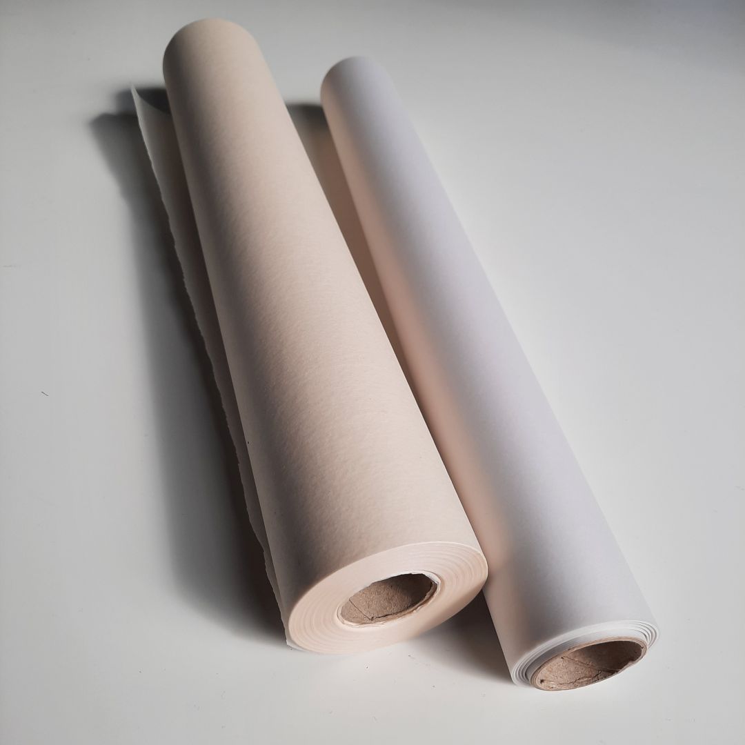 Zwei Skizzenrollen, die auf einer Tischplatte liegen. Es sind Rollen mit transparentem Skizzierpalpier.