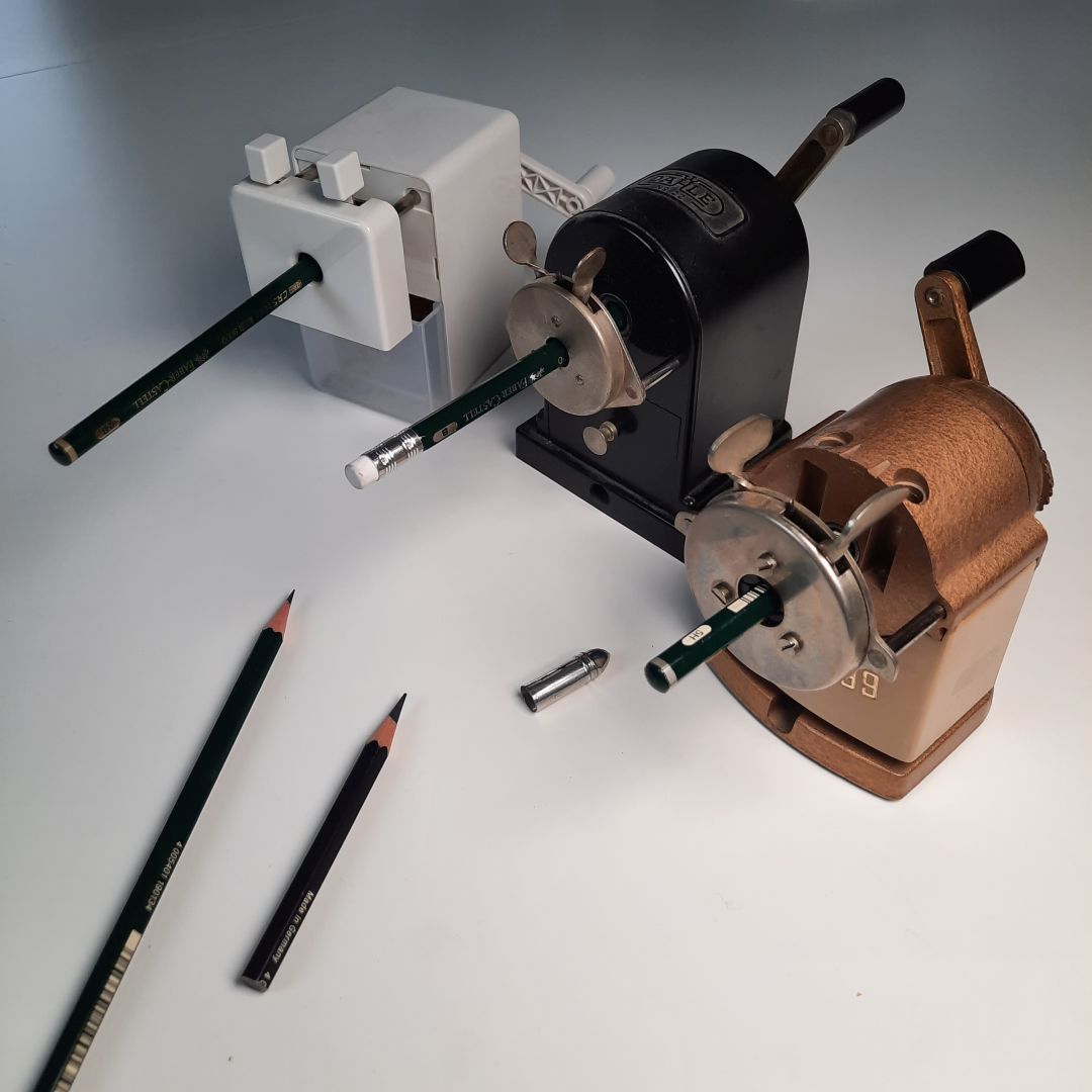 Drei Spitzmaschinen mit Kurbel, um Bleistifte anzuspitzen.