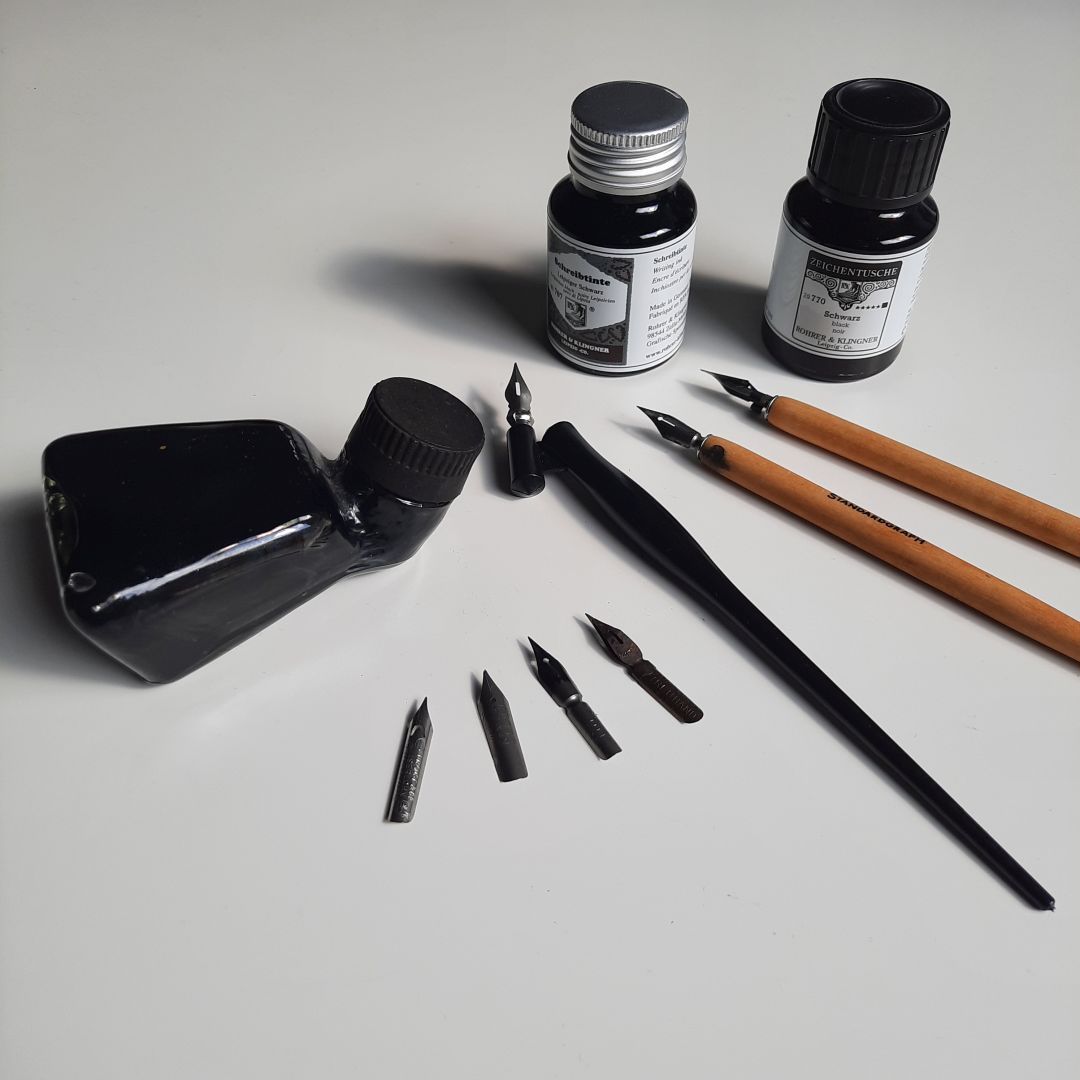 Drei Federhalter mit Tuschefedern und drei Gläschen mit Zeichentusche.