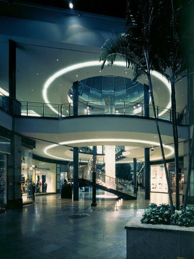 Innenaufnahme eines Einkaufszentrums mit einer runden Freitreppe und einem darüber zu sehenden Leuchtring.