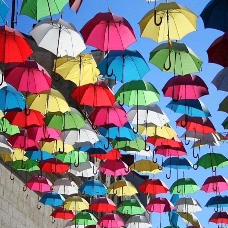 Open multi-coloured umbrellas hanging overhead Samur France