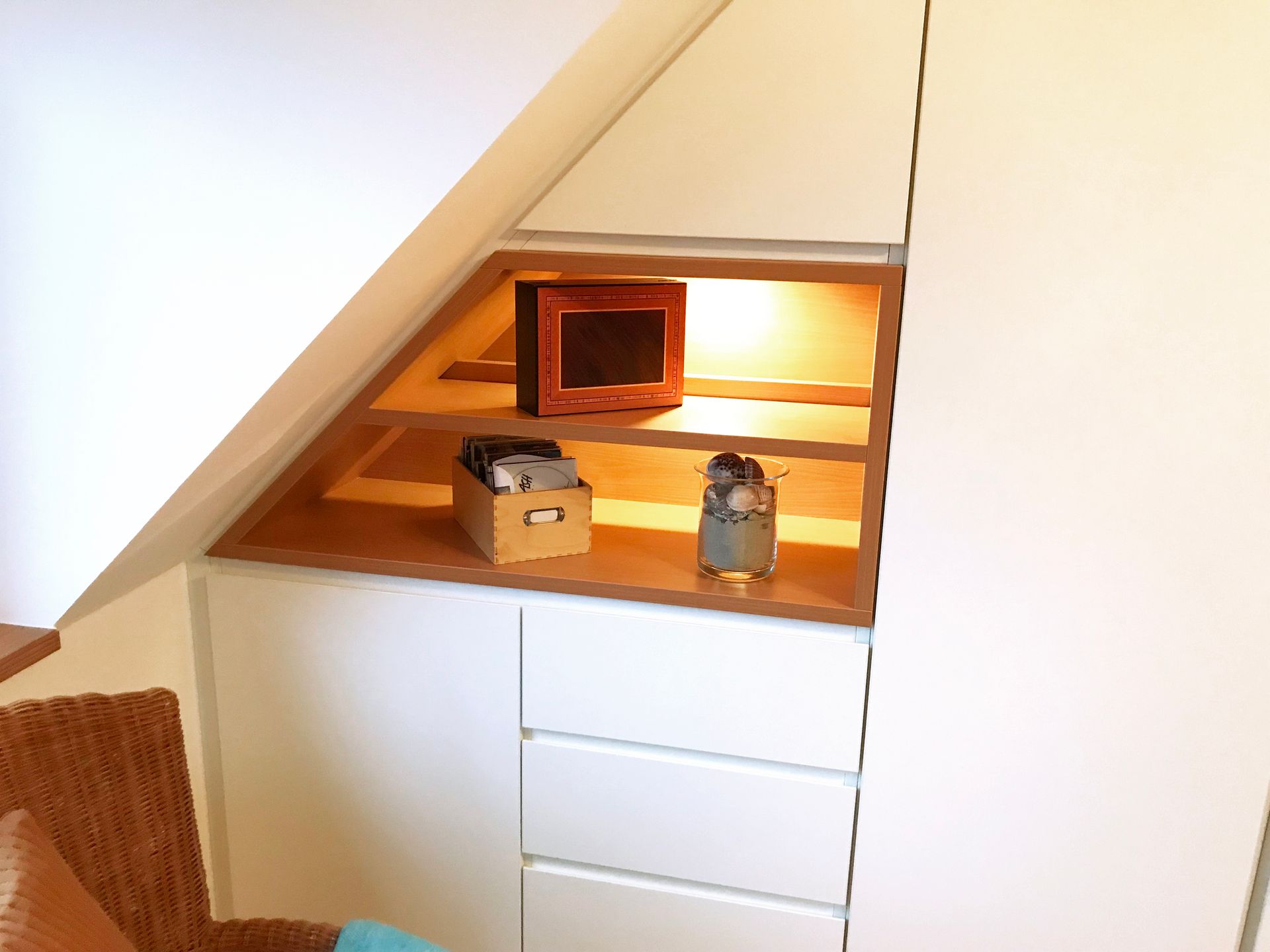 weißer Einbauschrank unter Dachschräge, integrierte Holzregale mit indirekter Beleuchtung, Schrankwand, Stauraum