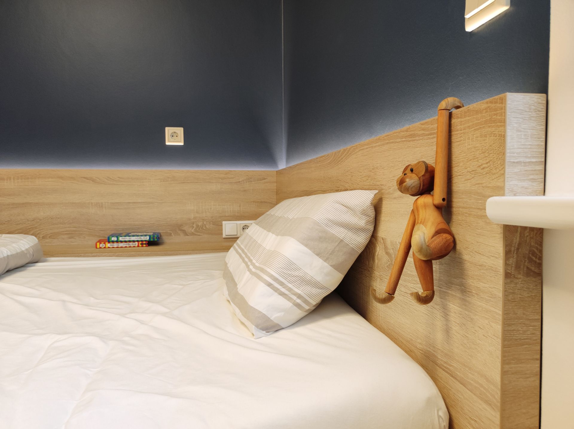 Jugendzimmer, maßgeschneidertes Bett mit integriertem Stauraum und Ablagefläche, indirekte LED-Beleuchtung