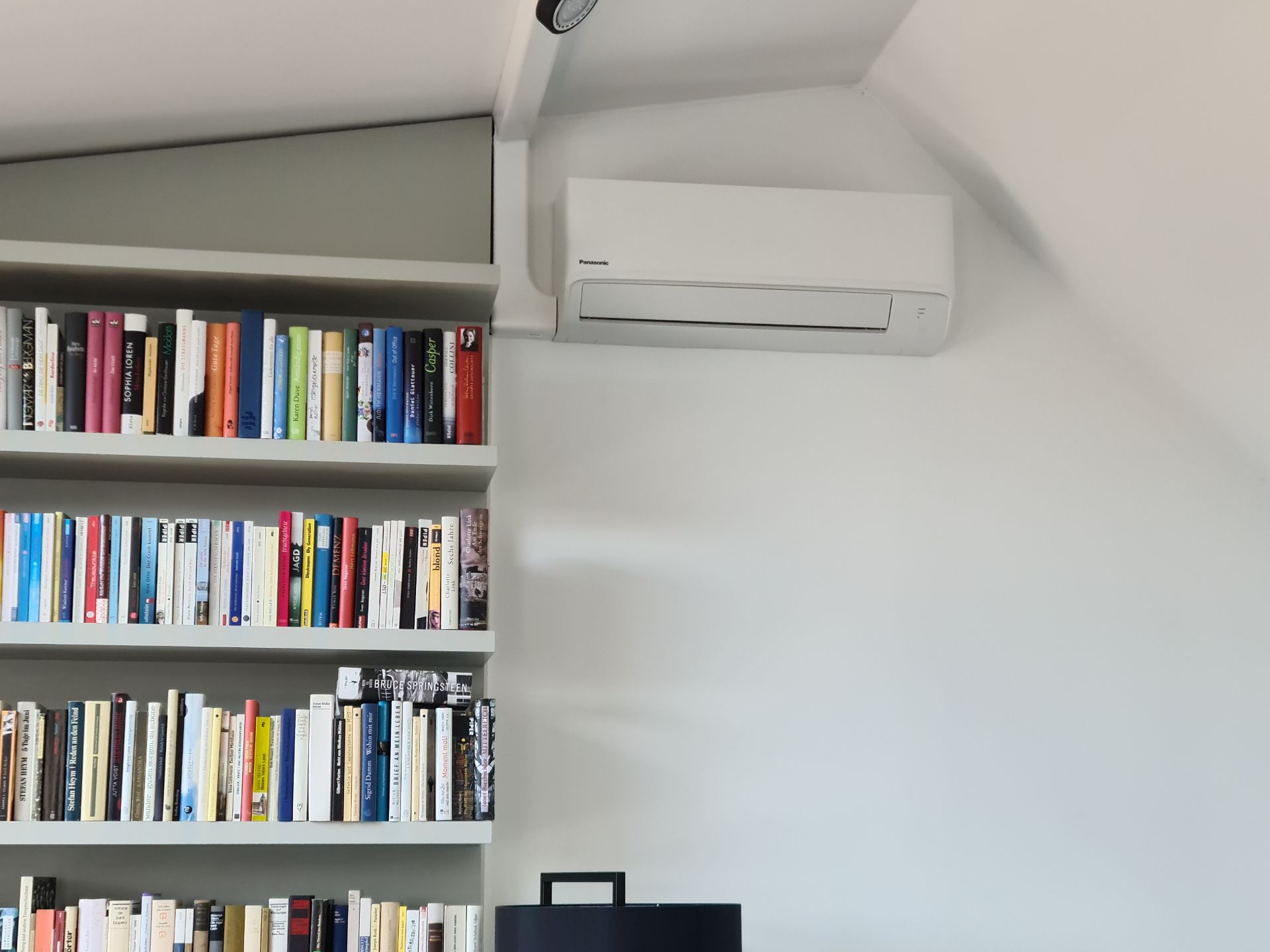 Klima neben Bücherregal