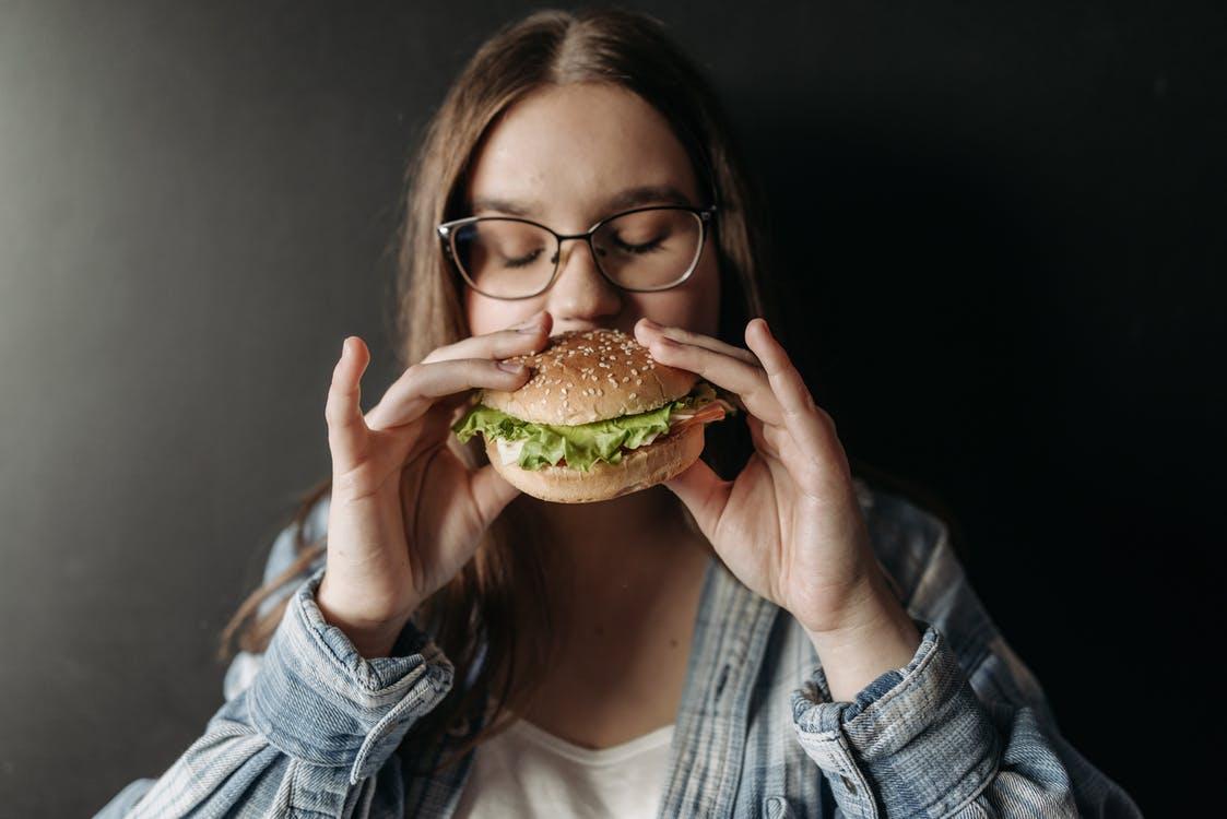 A woman eating Jersey City Hamburgers