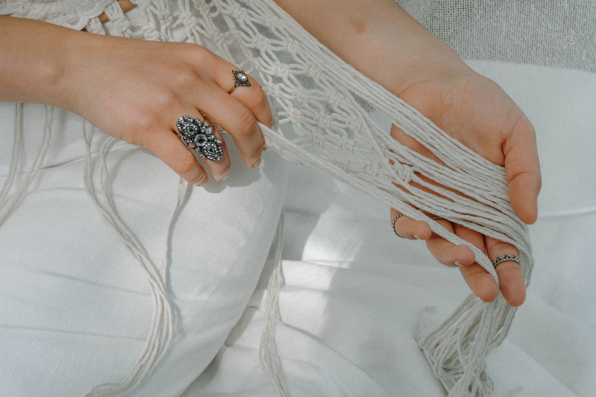 Detailaufnahme eines handgefertigten Outfits von Katyliz - Frau trägt Häkeloberteil mit Makramee-Details und Fransen