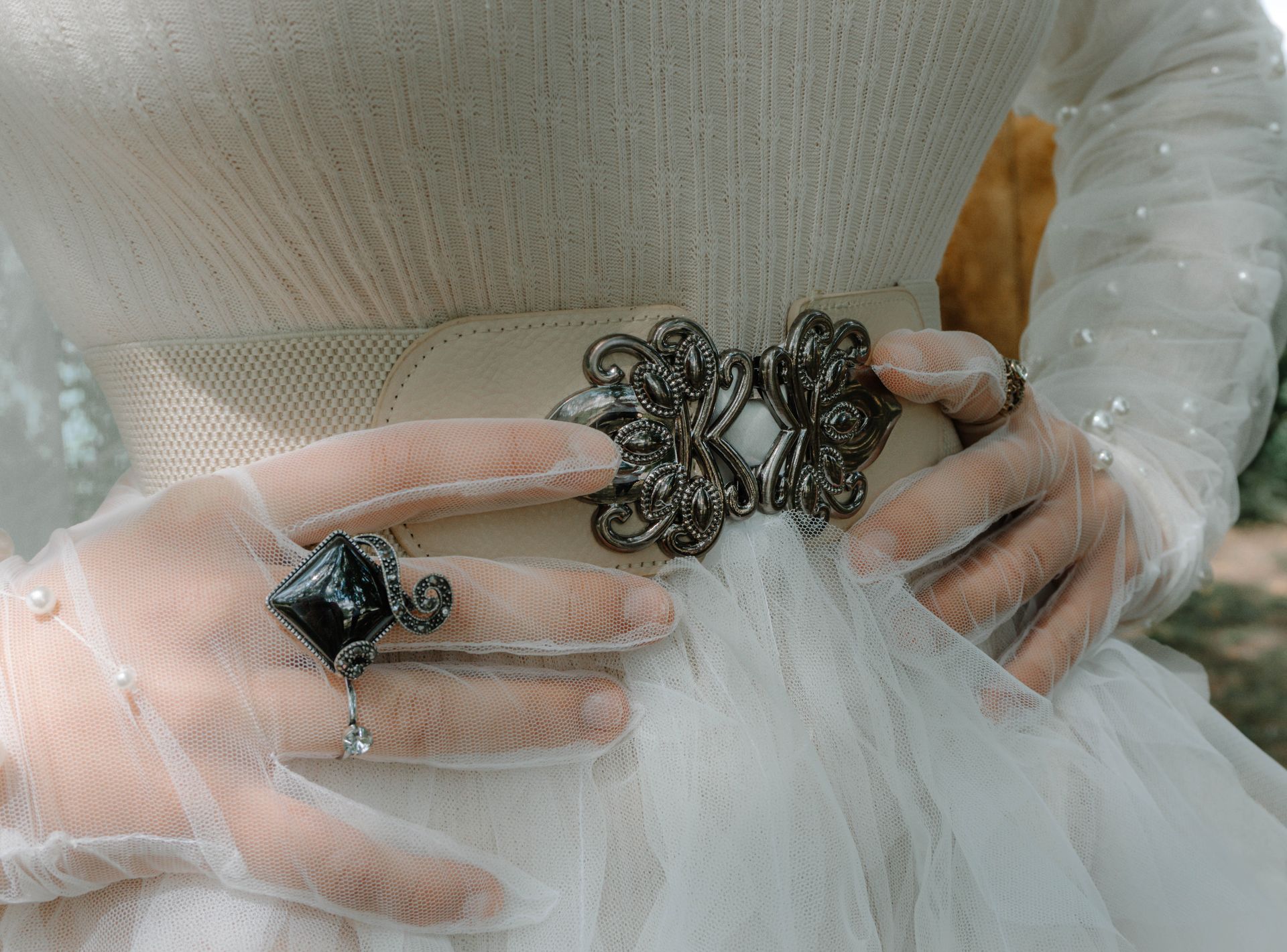Detailaufnahme eines handgefertigten Outfits von Katyliz - Frau trägt perlenbestickte Tüllhandschuhe dazu Ring und Gürtel