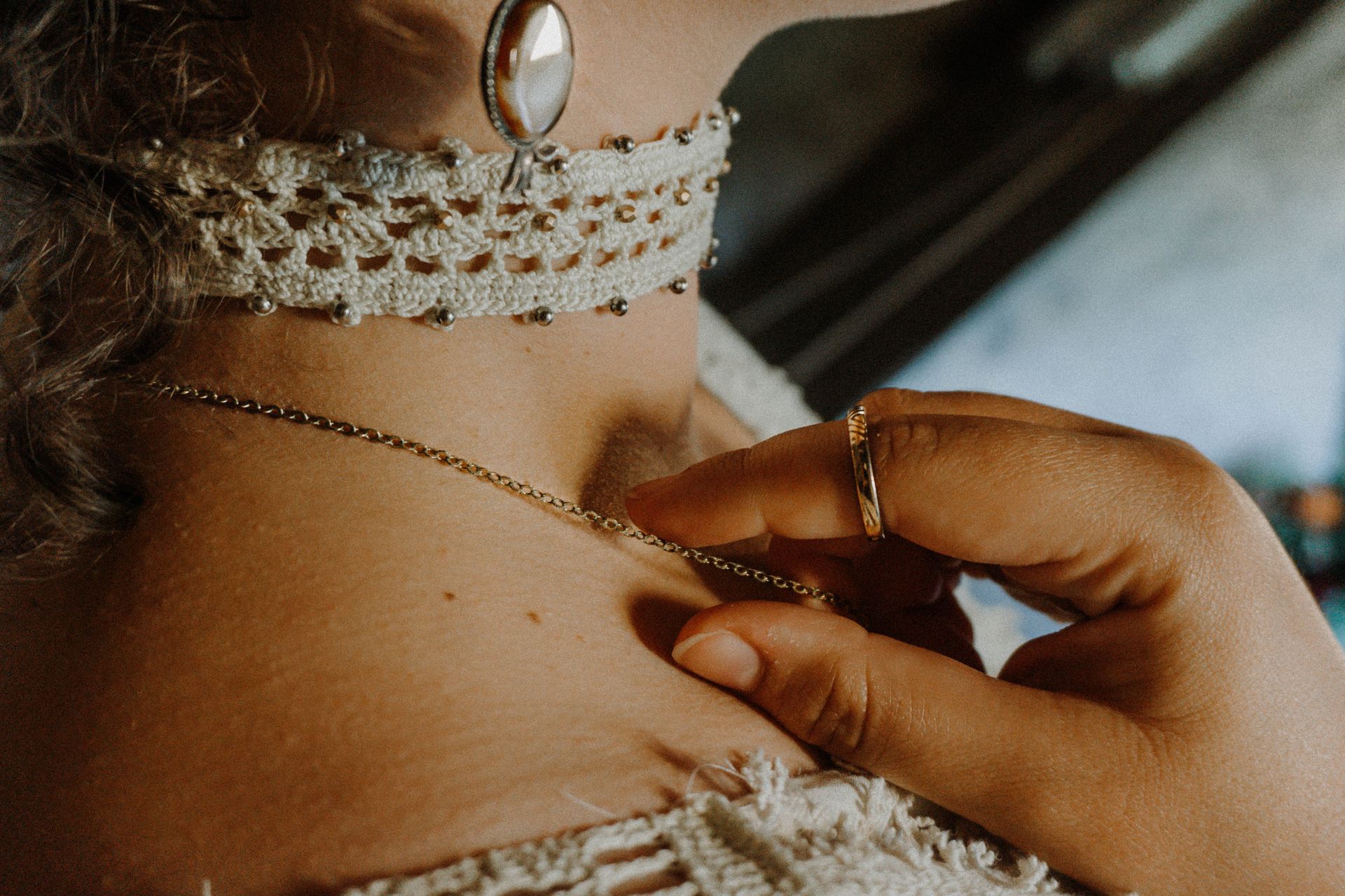 Detailaufnahme eines handgefertigten Outfits von Katyliz - Frau trägt gehäkeltes Halsband mit Perlen