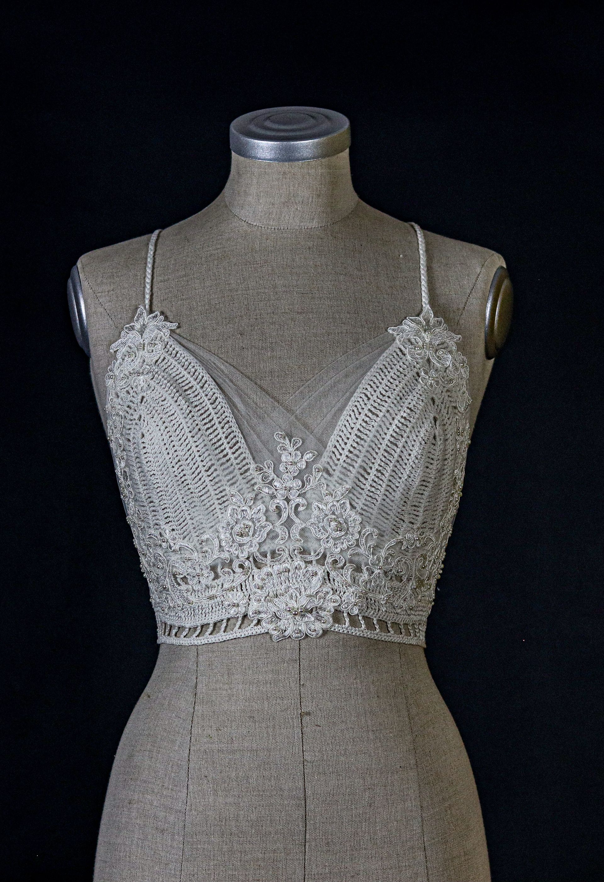 Handgefertigtes Häkeloberteil von Katyliz auf einer Büste – unkonventionelle Brautmode mit feiner Spitze und Perlen-Details