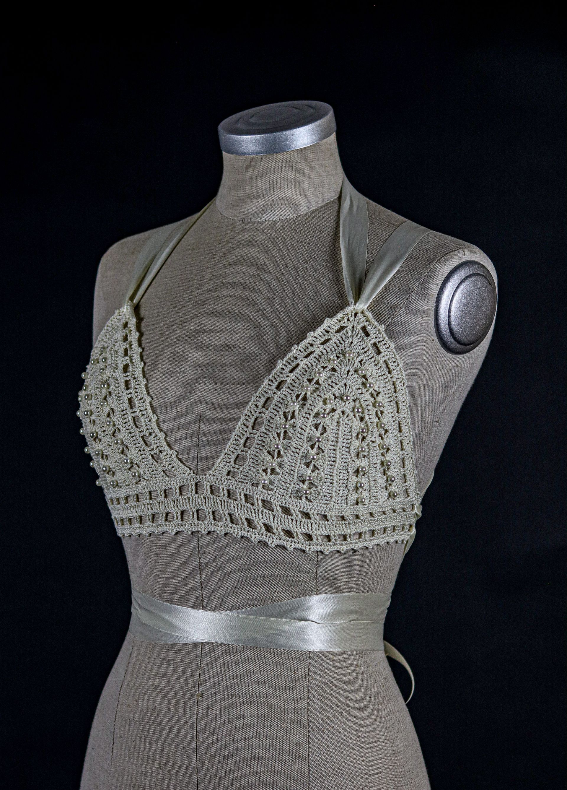 Handgefertigtes Häkeloberteil von Katyliz auf einer Büste – unkonventionelle Brautmode mit Perlen-Details