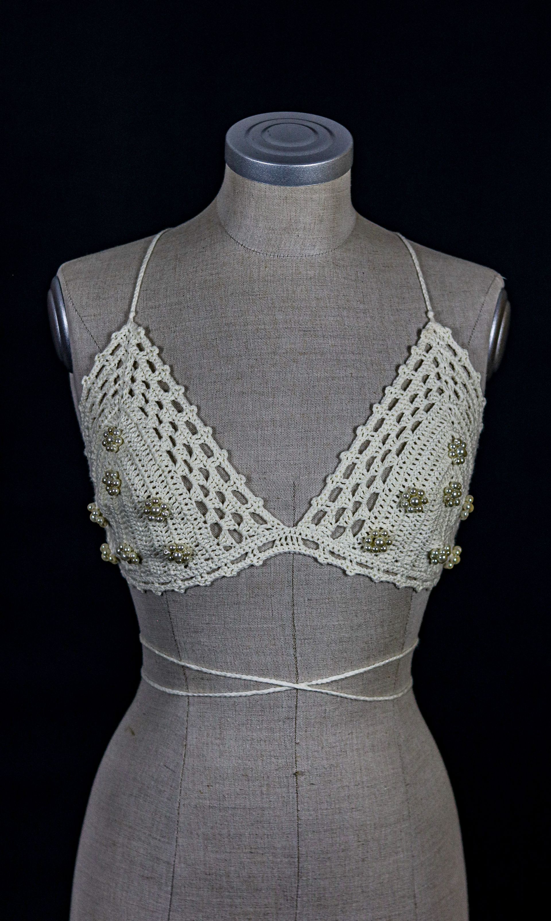 Handgefertigtes Häkeloberteil von Katyliz auf einer Büste – unkonventionelle Brautmode mit Perlen-Details