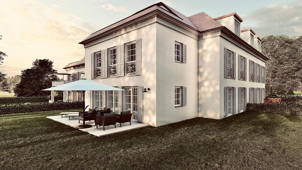 Zweistöckiges weißes Gebäude mit rotem Ziegeldach, Fensterläden und Terrasse mit Sonnenschirm auf einer Rasenfläche.