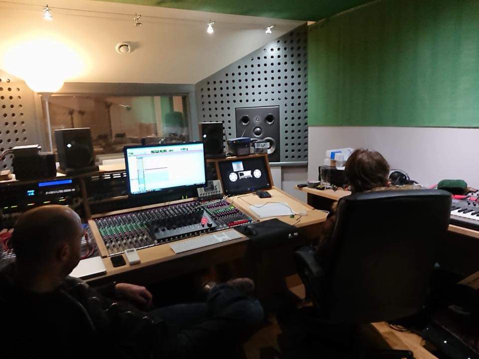 Gareth at the desk in the recording studio. He is sit in a chair and is facing away from the camera.