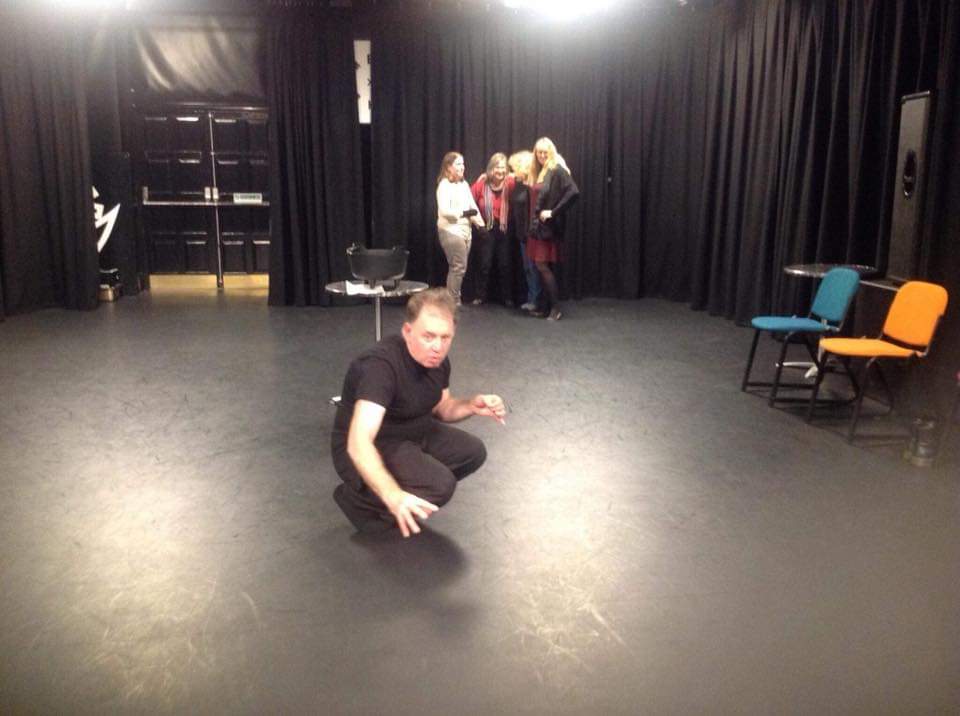 Michael is on his knees with one arm stretched out. whilst three people look on behind him