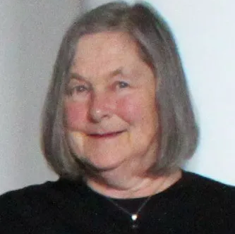 Head shot of Frances Duncan smiling with shoulder length hair, wearing necklace.