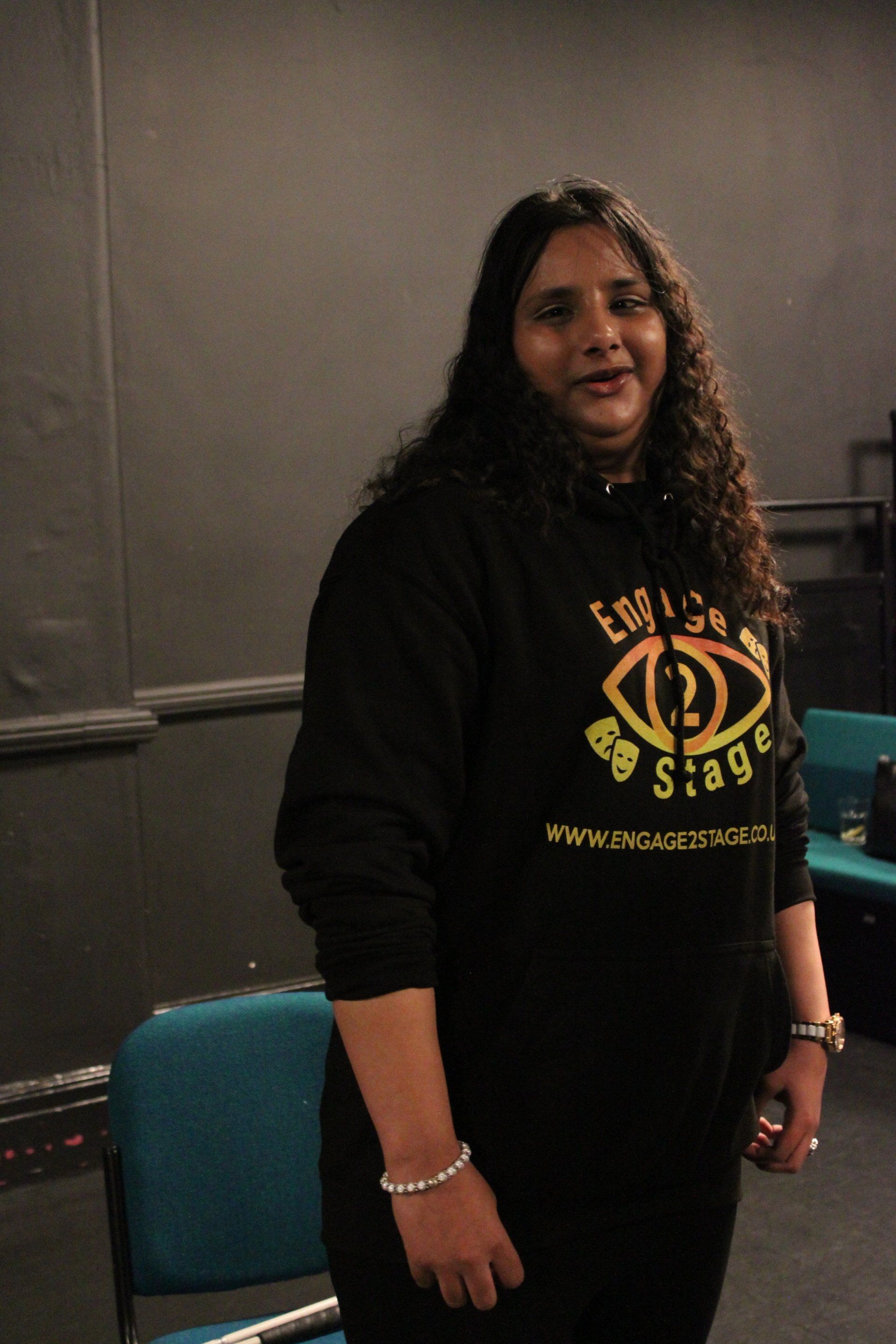 Zahra stood smiling in black box studio