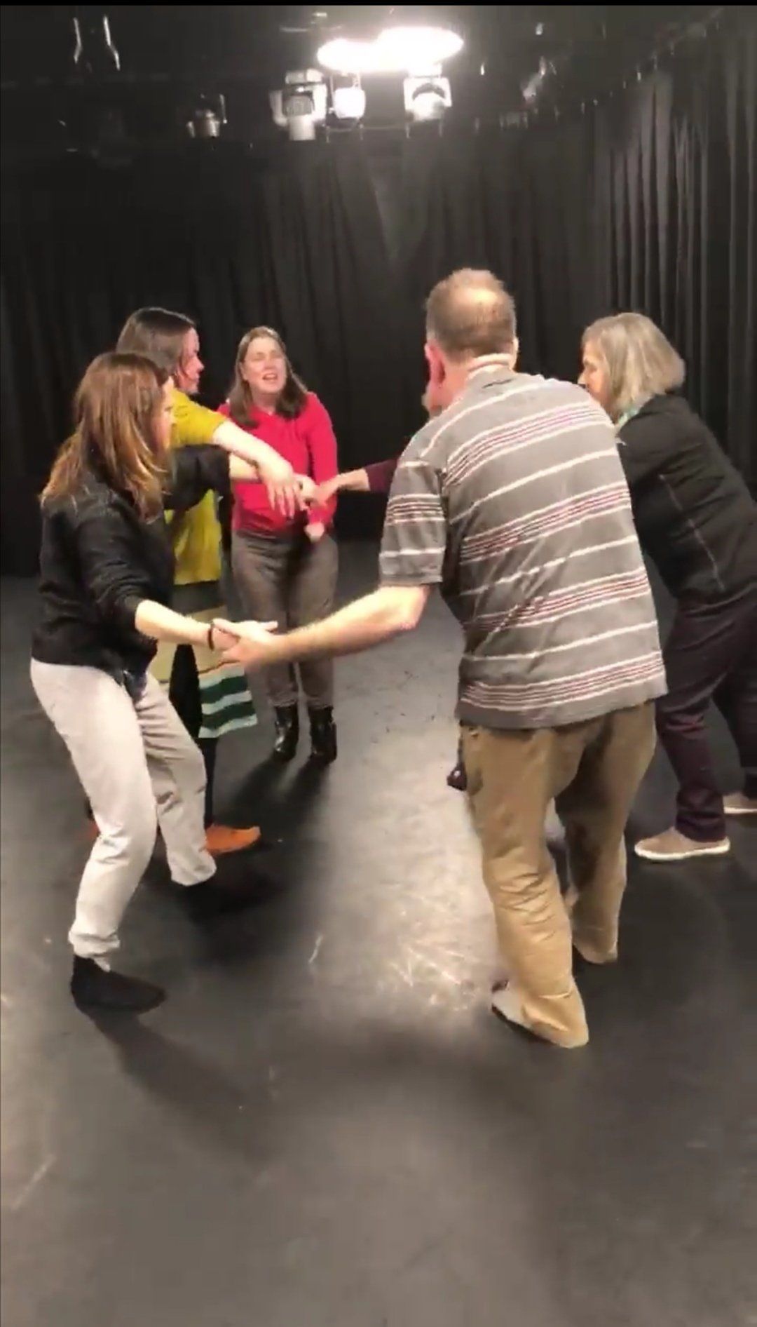 Group in circle holding hands and making wave movements/.