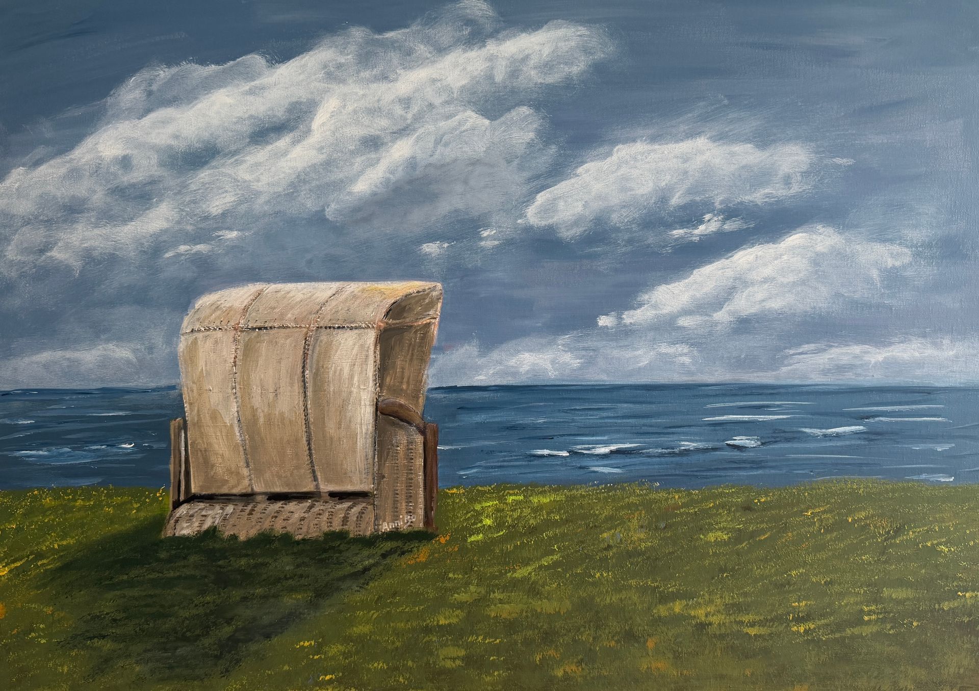 Strandkorb auf einer grünen Wiese unter einem wolkigen blauen Himmel in Meeresnähe