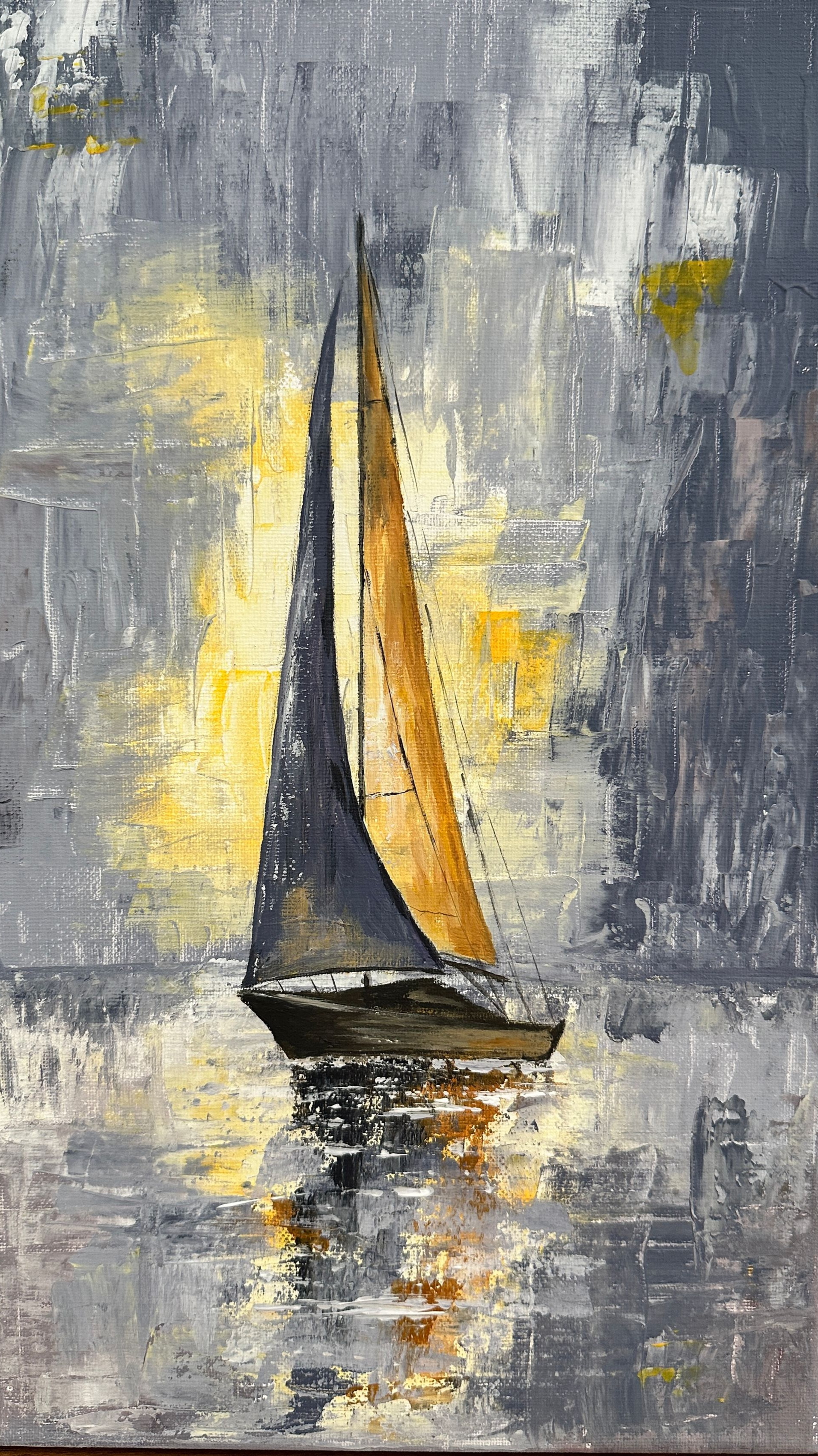 Ein Segelboot mit dunklen Segeln gleitet über spiegelndes Wasser unter einem grau-goldenen Himmel.