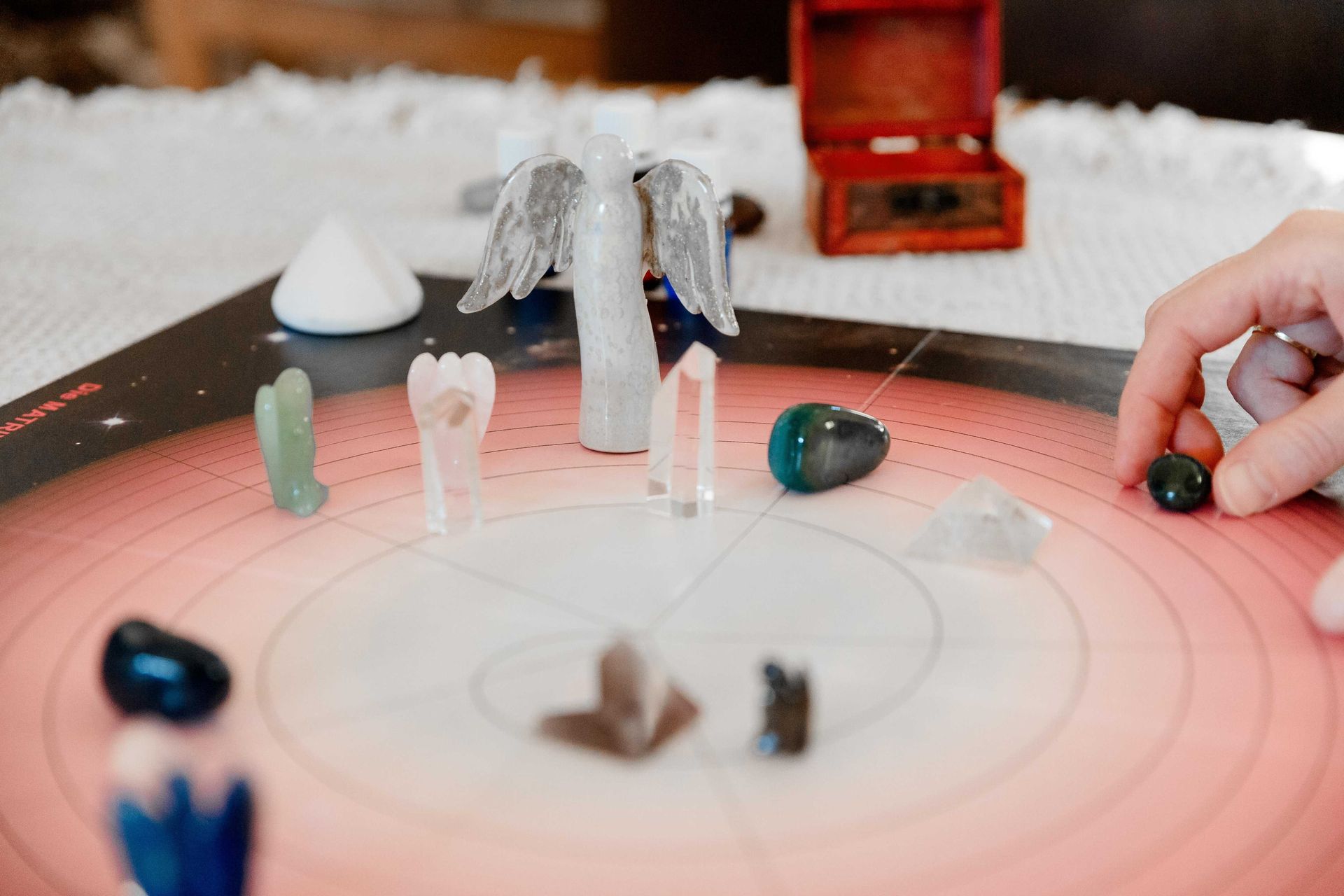 Aufgebautes Brett mit verschiedenen Edelsteinen und einer Engelsfigur aus Stein.