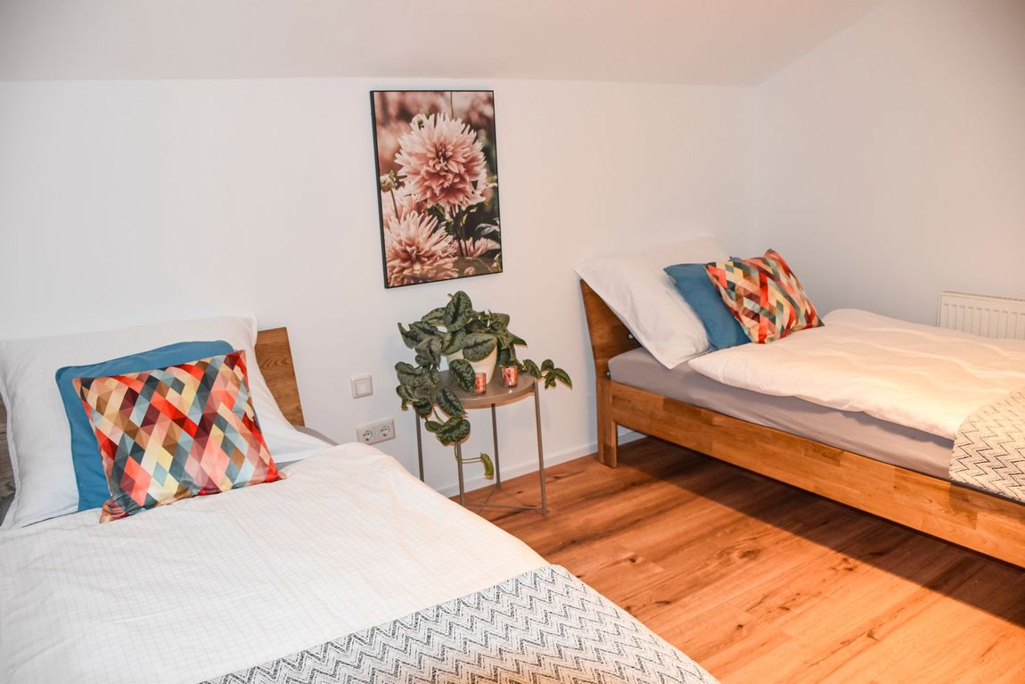 Stilvolles zweites Schlafzimmer mit zwei separaten Einzelbetten – ideal für Kinder oder getrennt reisende Gäste.