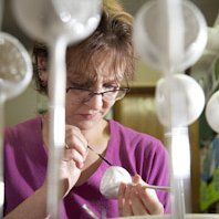 Glasmalerin bei der Arbeit, Sie mhlt gerade eine Christbaumschmuck Reflex Kugel.