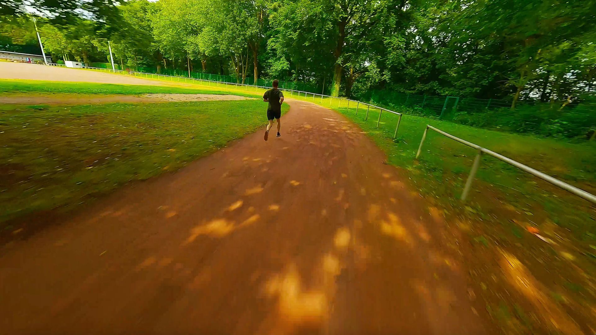 Ein Mann von hinten, wie er auf einer Laufstrecke rennt.