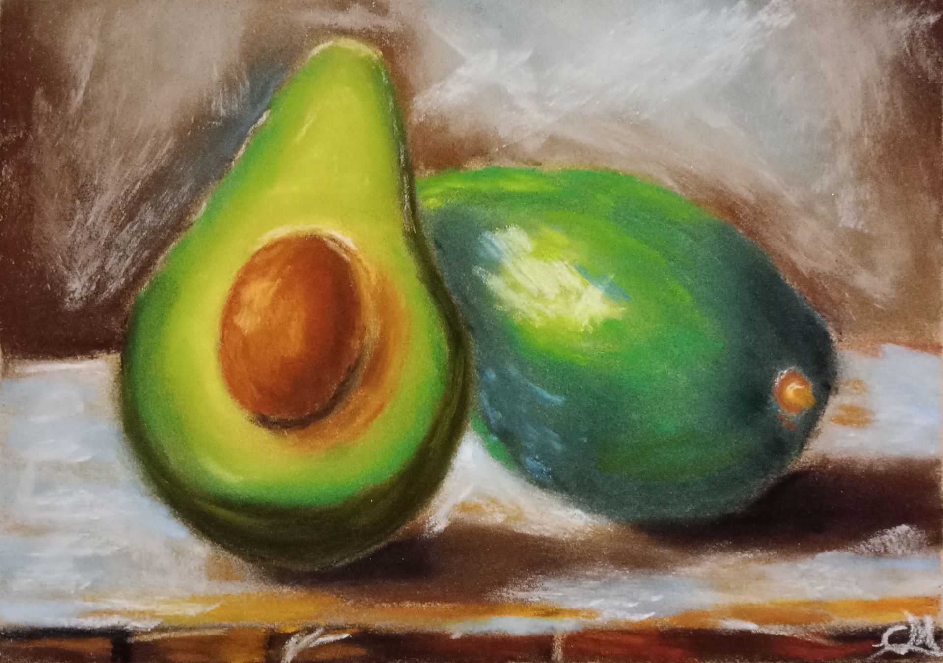 Eine gemalte Avocado, eine halbierte und eine ganze, auf einer braunen Oberfläche vor einem unscharfen Hintergrund.