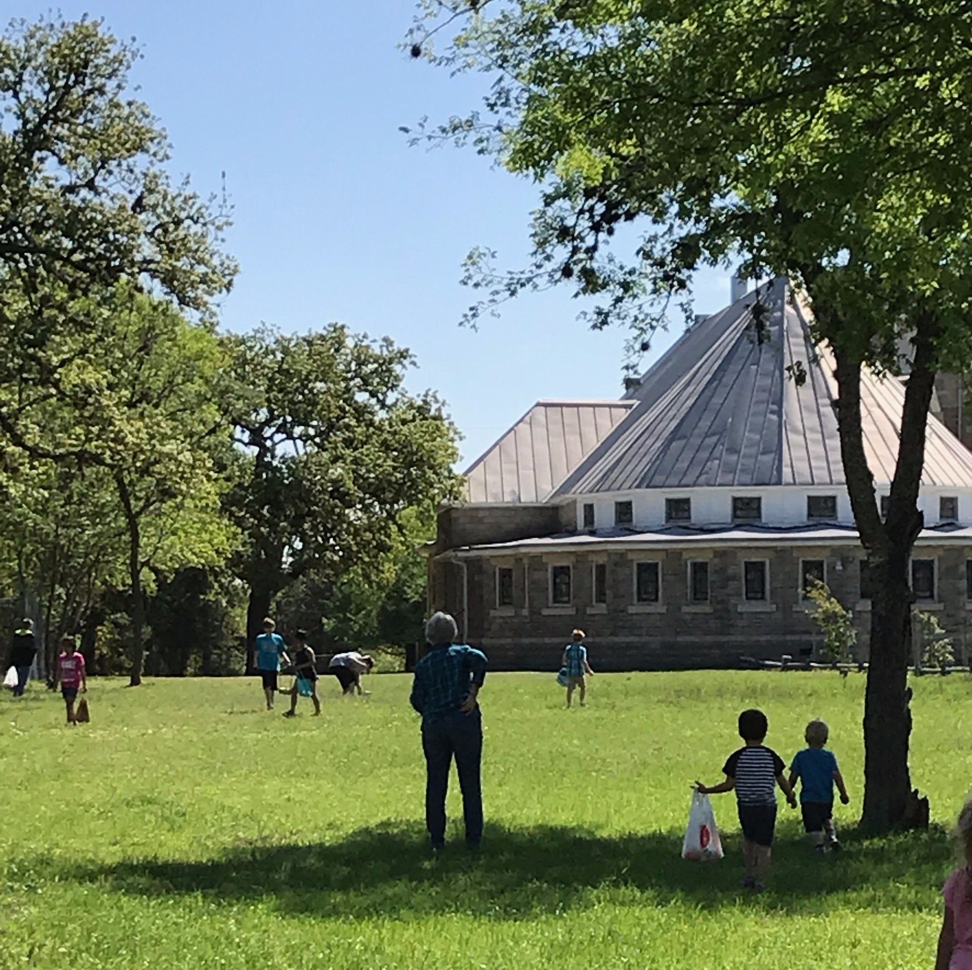 children in a grassy field in front of a gothic style church
