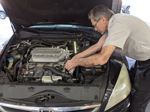 Leonard the owner working on an auto engine