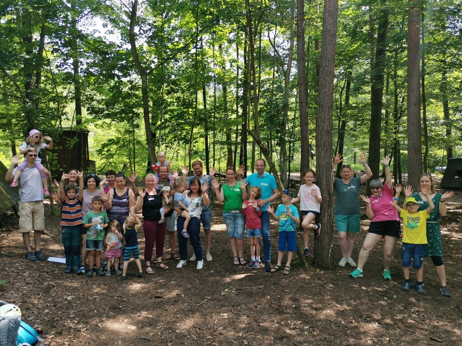 Gruppenbild im Wald von Familien mit Kindern mit Hörbehinderung und Geschwistern