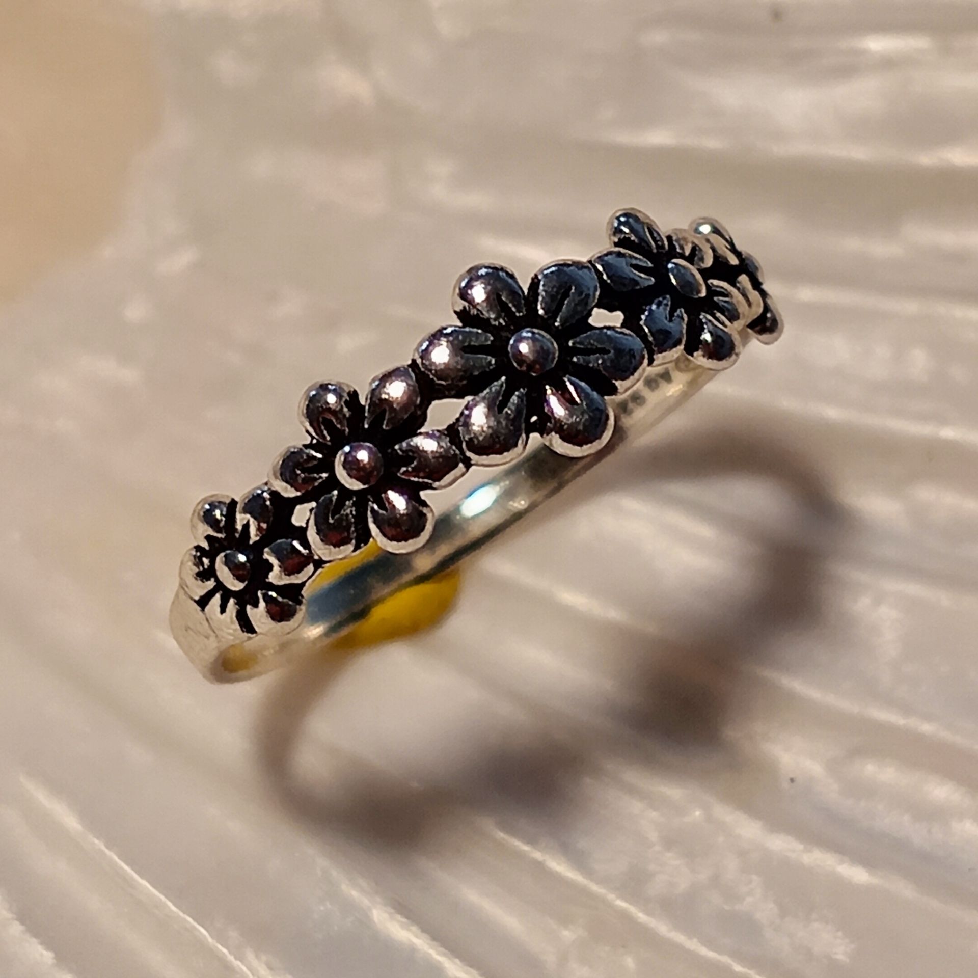 Silberner Ring mit floralem Muster.