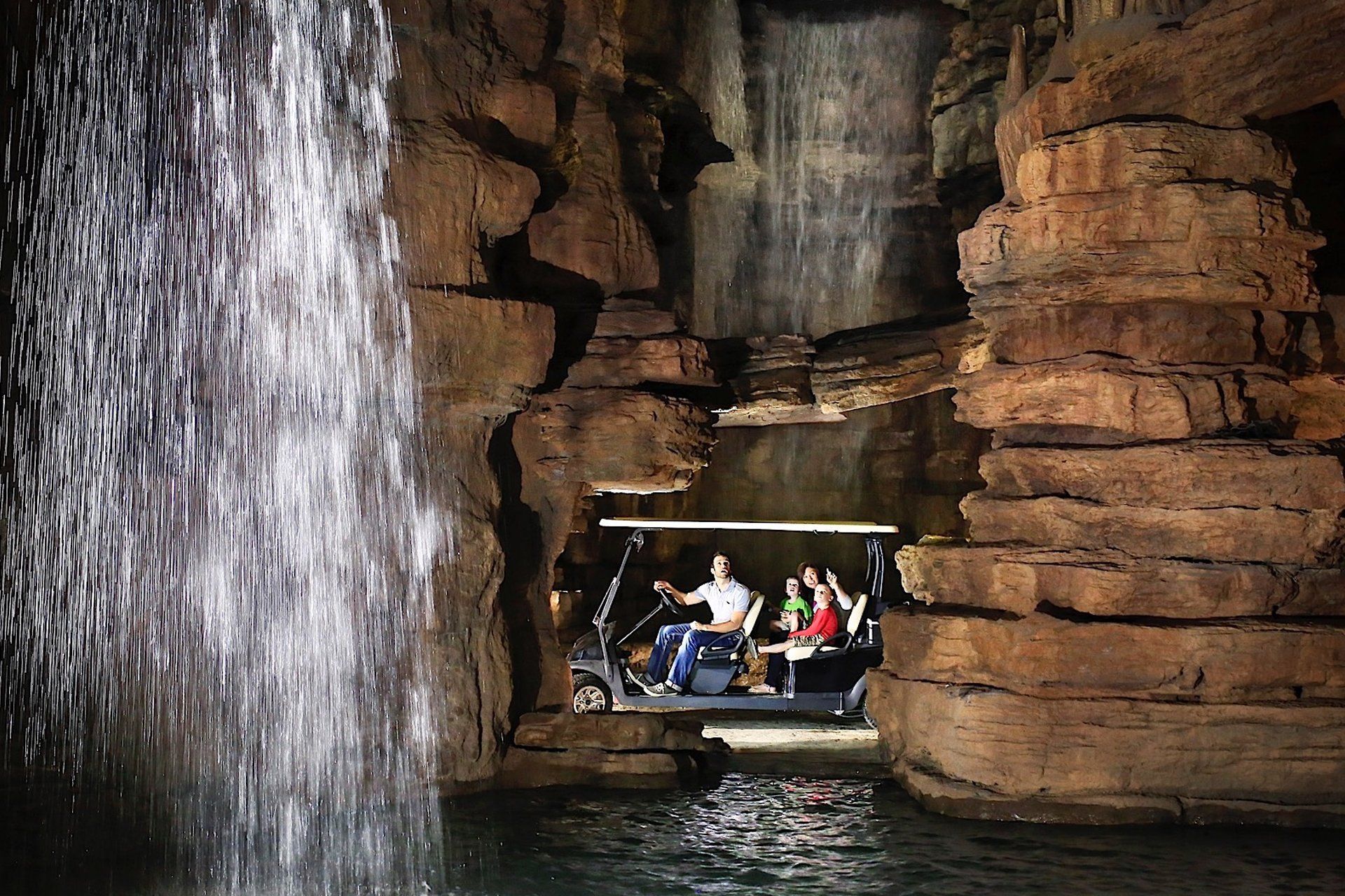 Photo of a golf cart tour of a cave with a waterfall.