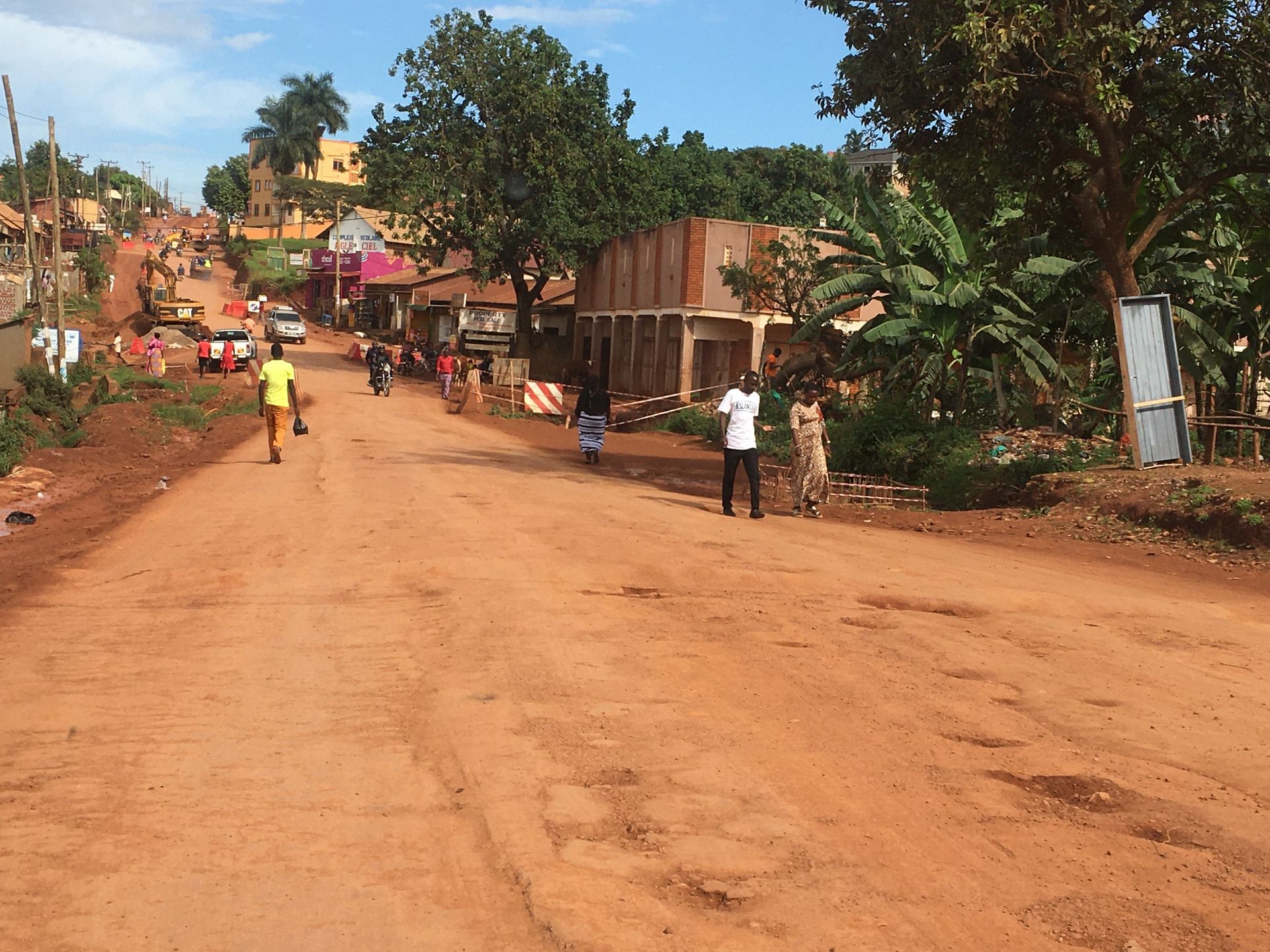 Klassische unbefestigte Straße mit rotem Lehm in Kampala, Uganda