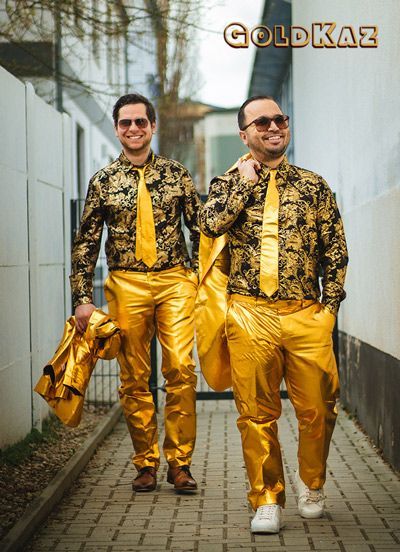 Die Musiker von GoldKaz im goldenen Outfit gehen wie Models spazieren