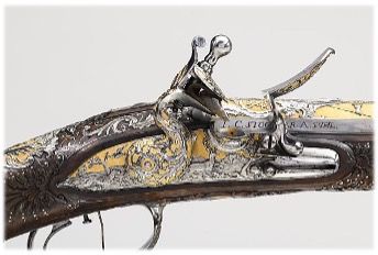 Nahaufnahme einer reich verzierten antiken Steinschlosspistole mit aufwendigen Silber- und Goldverzierungen.