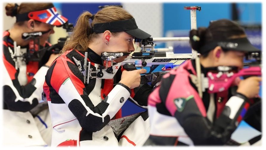 Schützen im Wettkampf, die mit Gewehren auf Ziele zielen. Sie tragen spezielle Schießbekleidung und Visiere.