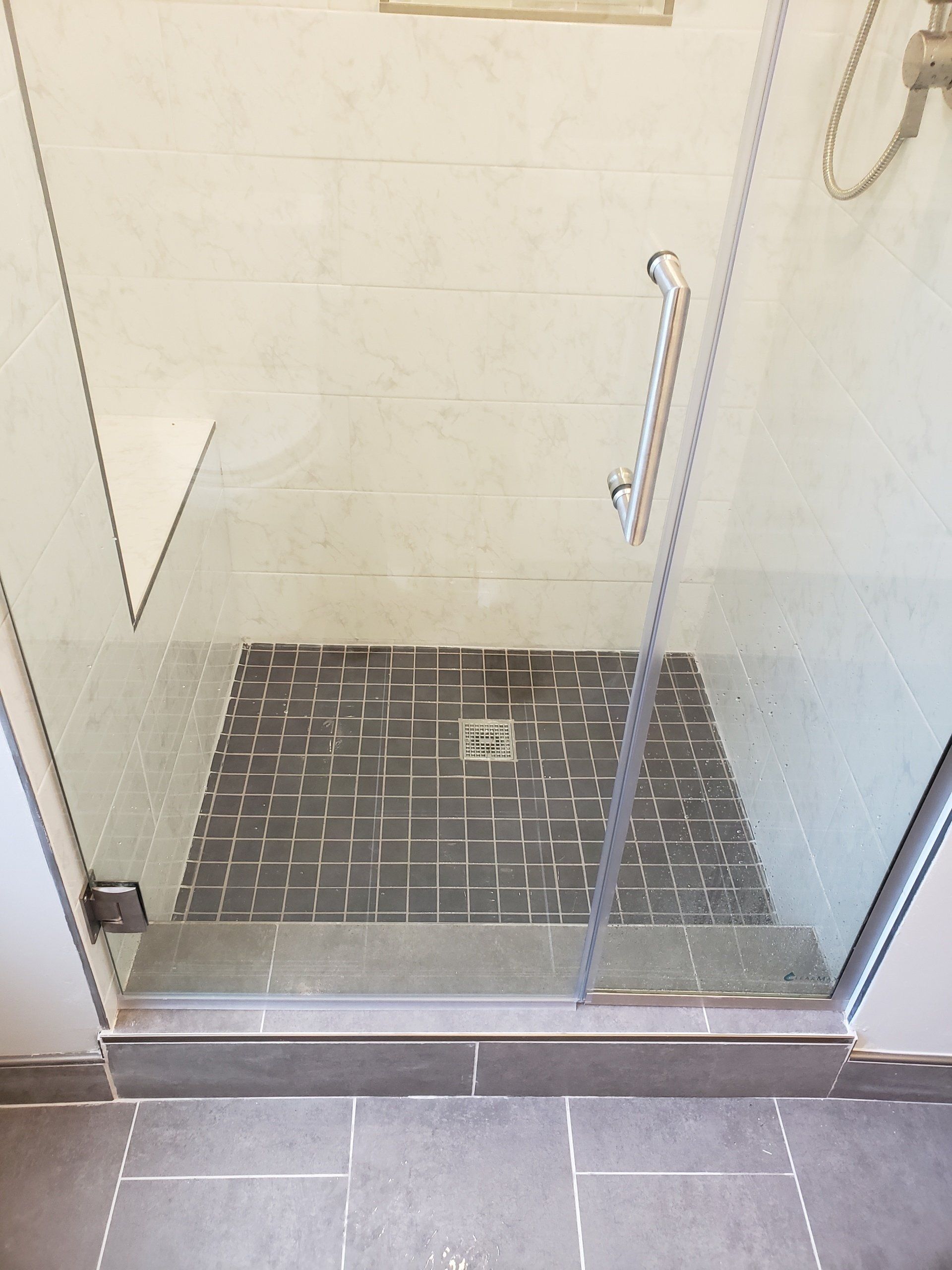 Close up of gray tiles on bathroom floor and shower stall floor in elkins park bathroom remodel