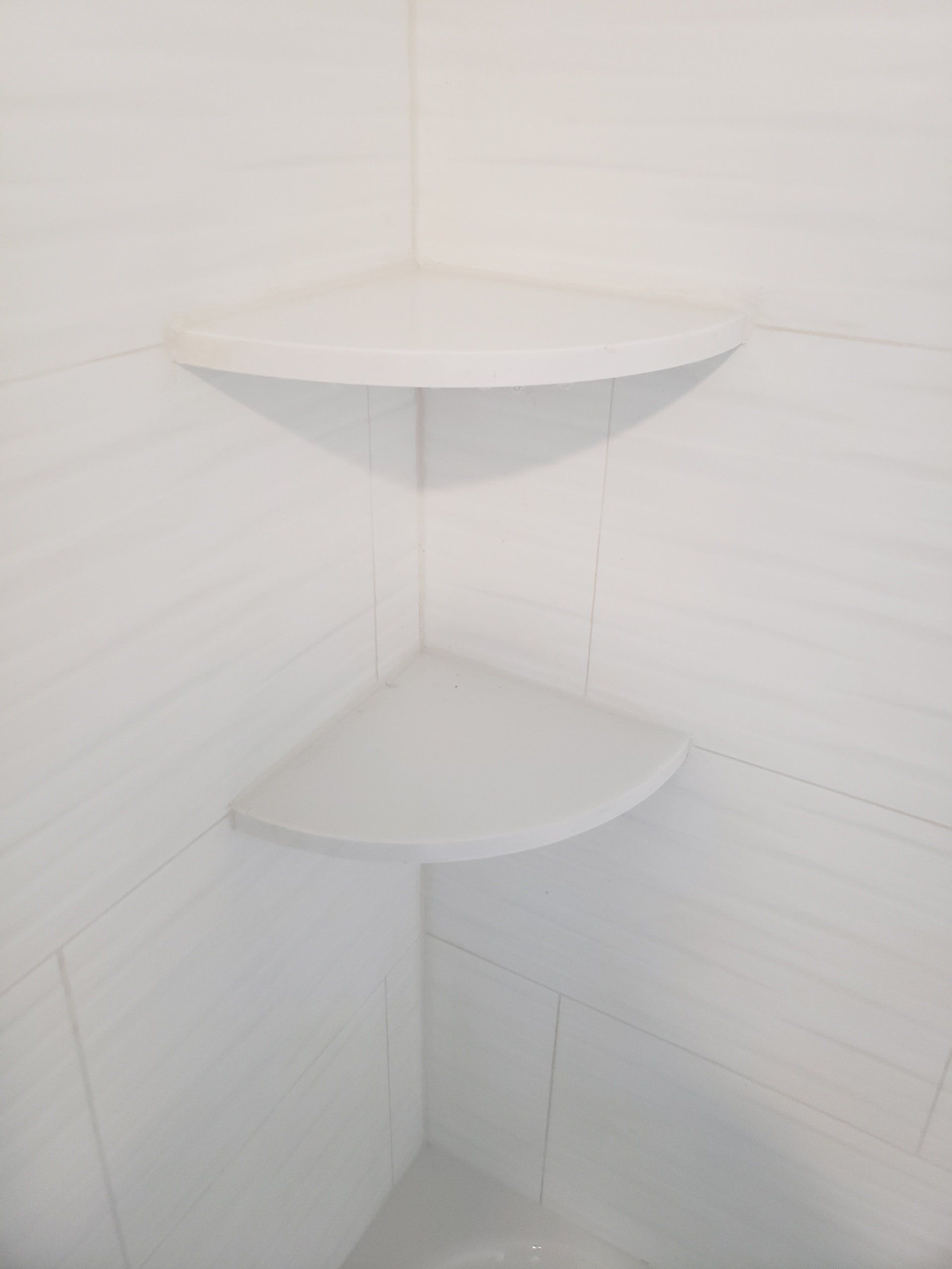 Close up of corner shower shelves in this bathroom remodel in Willow Grove.