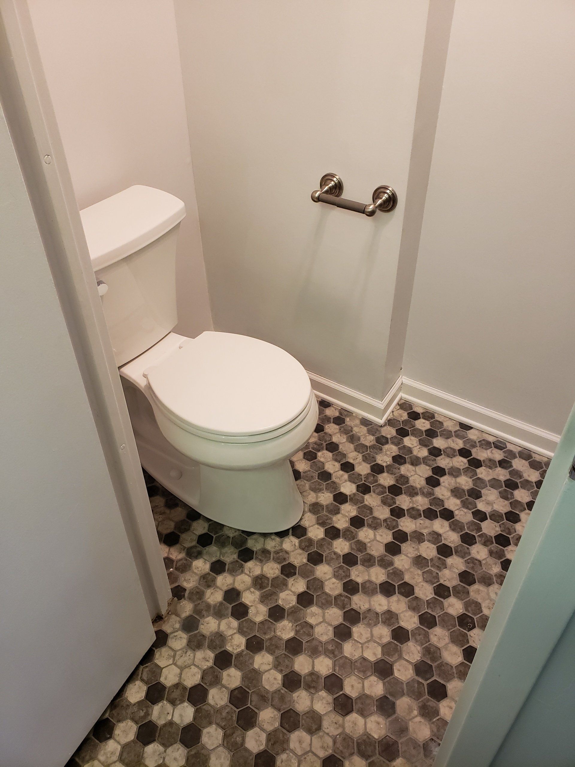 Jenkintown condo bathroom remodel close up of room with toilet and continuation of mosaic floor tiles.