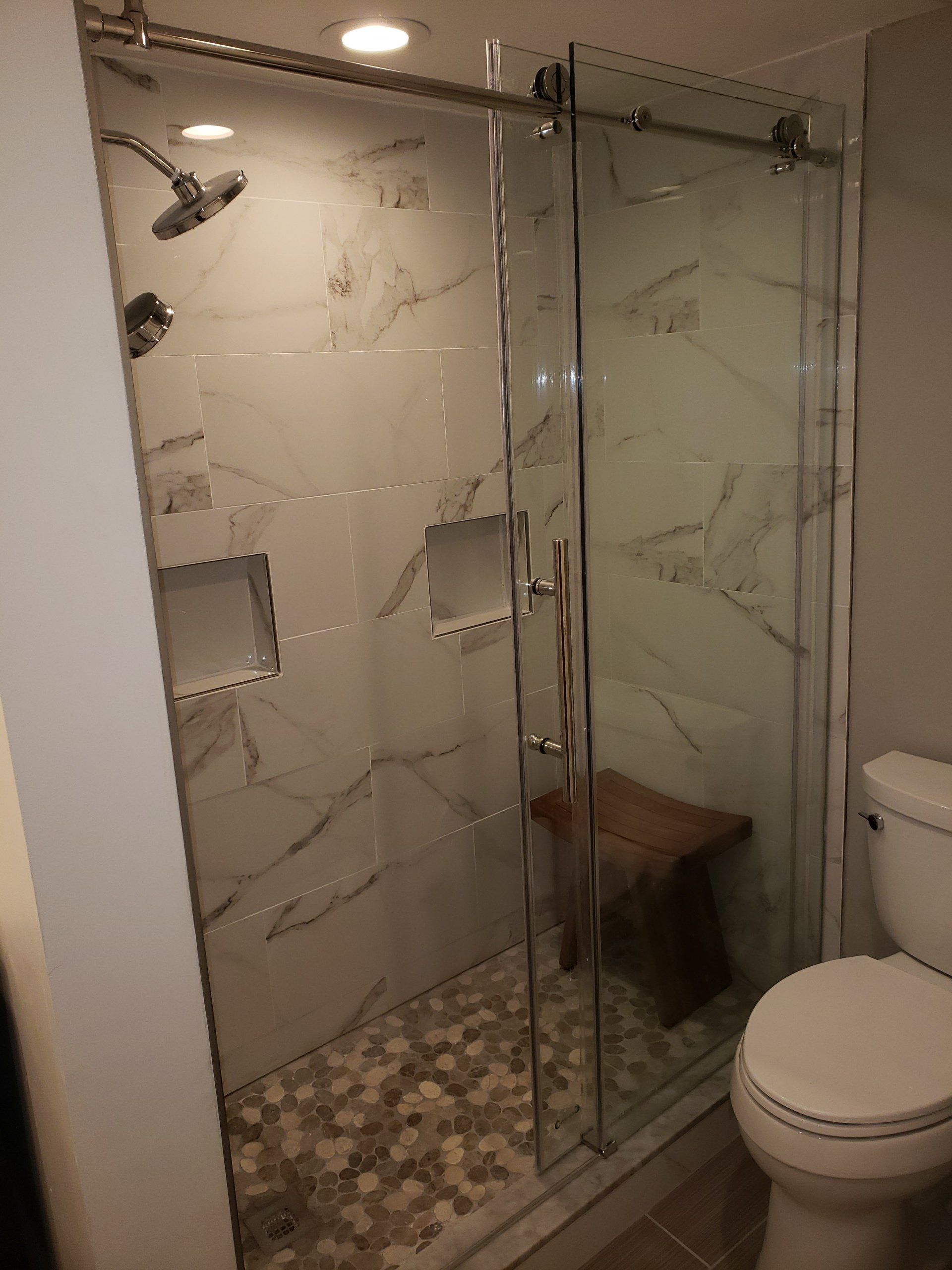 Frameless slider shower doors, shower niches and marble tile in Jenkintown bathroom remodel