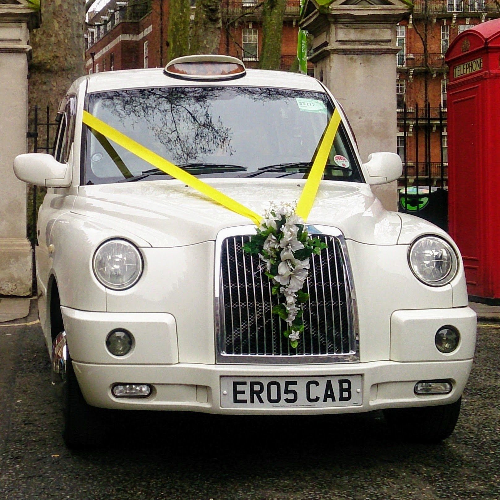 White Wedding Taxi with Bright Yellow Wedding Ribbon